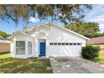 Charming single-story home with a bright blue door and well-maintained front yard at 2308 Donegan Pl, Orlando, FL 32826