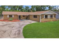 Charming single story home with a circular driveway and well-manicured lawn at 2804 Clearfield Ave, Orlando, FL 32808