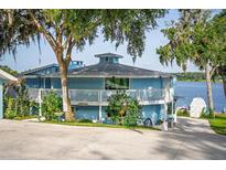 Stunning two-story home with a white railing balcony and a lake view at 36607 E Eldorado Lake Dr, Eustis, FL 32736