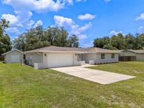 Charming home showcasing a well-maintained lawn and an attached two-car garage at 7360 Canal Dr, Sanford, FL 32771