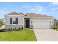 Charming single-story home with well-manicured lawn and attached two-car garage at 756 Rioja Dr, Minneola, FL 34715