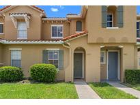 Charming townhome with a terra cotta roof, green shutters, and well-manicured landscaping at 7625 Long Island Dr, Kissimmee, FL 34747