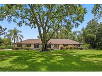Well-manicured lawn and mature trees enhance this home's curb appeal, perfect for enjoying outdoor living at 9601 Ambleside Dr, Windermere, FL 34786