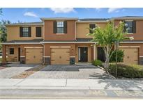 Inviting townhome featuring a well-maintained, colorful exterior and paver driveway at 1575 Downy Birch Ln, Longwood, FL 32750