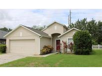 Charming single-Gathering home with a two-car garage, manicured lawn, and inviting front entrance at 1868 Hammock Moss Dr, Orlando, FL 32820