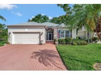 Charming single-story home with a brick driveway, well-manicured lawn, and beautiful landscaping at 2500 Castle Pines St, Clermont, FL 34711