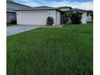 Charming single-story home featuring a well-maintained front yard and a two-car garage at 2765 Montego Bay Blvd, Kissimmee, FL 34746