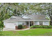Charming single-story home with attached garage and lush landscaping at 33042 Lake Bend Cir, Leesburg, FL 34788