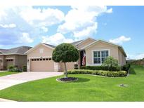 Inviting single-story home featuring manicured lawn, neat landscaping, and a charming, neutral color scheme at 3574 La Jolla Dr, Clermont, FL 34711