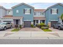 Charming blue two-story townhomes, each with a private garage and well-manicured landscaping at 366 Reed Grass Dr, Oviedo, FL 32765