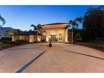 Elegant home featuring a circular driveway, mature landscaping and grand entrance with stately columns at 4048 Gilder Rose Pl, Winter Park, FL 32792