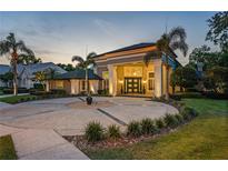 Stunning home featuring a circular driveway and grand entrance with columns and mature landscaping at 4048 Gilder Rose Pl, Winter Park, FL 32792