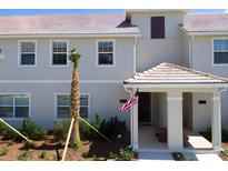 Charming home with a tiled roof, manicured lawn, and an inviting covered entryway showcasing the American flag at 4912 Windermere Ave, Kissimmee, FL 34746