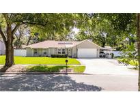 Charming single-story home features a well-manicured lawn, mature trees, and a convenient carport in a desirable neighborhood at 5177 Chesapeake Ave, Orlando, FL 32808