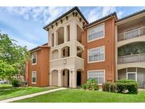 Attractive condo building featuring Mediterranean-style architecture, lush landscaping, and a well-maintained lawn at 5512 Metrowest Blvd # 201, Orlando, FL 32811
