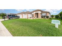Charming single-story home with beautiful lawn, manicured landscaping, and neutral-toned stucco exterior at 8865 Se 119Th St, Summerfield, FL 34491