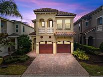 Stunning two-story home with a tile roof, two-car garage, and brick paved driveway at 1041 Castle Pines Ct, Reunion, FL 34747