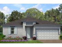 Charming single-story home featuring a two-car garage and a well-manicured lawn with colorful flower beds at 1414 Ethan Manor Rd, Haines City, FL 33844