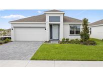 Charming single-Gathering home features a two-car garage, manicured lawn, and neutral-colored exterior at 1568 Gardiner St, Haines City, FL 33844