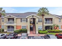 Inviting condominium exterior with well-maintained landscaping, balconies, and covered parking spaces at 1910 Summer Club Dr # 108, Oviedo, FL 32765
