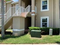 Exterior of a multi-unit building with staircases, landscaping, and clearly marked unit numbers at 2826 Osprey Cove Pl # 103, Kissimmee, FL 34746
