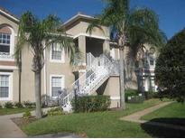 Charming condo featuring a two-story entrance and beautifully maintained landscaping with mature palms at 2826 Osprey Cove Pl # 103, Kissimmee, FL 34746