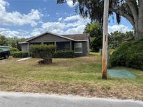 Charming single-story home featuring a cozy screened porch and well-maintained landscaping, enhancing curb appeal at 3411 Hughey St, Sanford, FL 32771