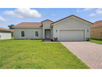 Charming single-story home featuring a well-manicured lawn and a classic tile roof at 436 Caraway Dr, Kissimmee, FL 34759
