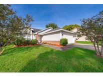 Charming single-Gathering home with a well-maintained lawn and landscaping and an attached two-car garage at 6512 Grosvenor Ln, Orlando, FL 32835