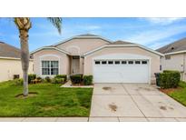 Charming single-story home featuring a two-car garage and neatly landscaped front yard at 8152 Fan Palm Way, Kissimmee, FL 34747