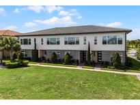 Modern townhome featuring a well-manicured lawn, symmetrical landscaping, and expansive windows for great natural light at 10108 Sunnifa Aly, Orlando, FL 32832