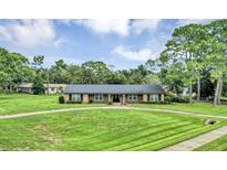 Beautiful ranch style home with a circular driveway and well-manicured lawn and landscaping at 1071 Deer Run Dr, Winter Springs, FL 32708