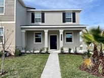 Charming two-story home featuring well-manicured lawn and inviting entrance with a concrete path at 15579 Water Spring Blvd, Winter Garden, FL 34787