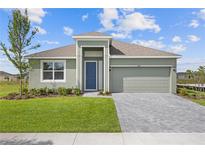 Charming single-story home featuring a manicured lawn, brick paver driveway, and a two-car garage at 1580 Gardiner St, Haines City, FL 33844