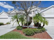 Inviting two-story townhome with well-maintained lawn, decorative trees, and mulch beds at 1730 Spicebush Ct, Orlando, FL 32828