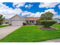 Charming single-story home featuring a well-maintained lawn and a two-car garage at 2223 Fairmont Cir, Orlando, FL 32837