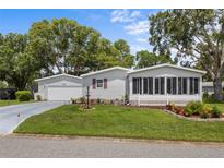 Charming home featuring a well-manicured front yard and a lovely screened-in porch for relaxing outdoors at 25333 Casa Del Lago Ln, Leesburg, FL 34748
