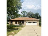 Charming single-story brick home featuring a large two-car garage and well-maintained front lawn at 34008 S Haines Creek Rd, Leesburg, FL 34788