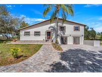 Beautiful two-story home with a large palm tree, brick walkway and spacious driveway at 40140 Swift Rd, Eustis, FL 32736