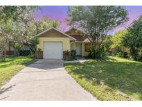 Charming single Gathering home featuring a one car garage and well maintained lawn with mature trees at 1007 Glendale St, Orlando, FL 32807