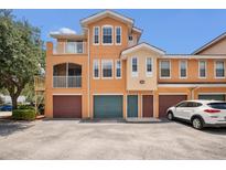 Three-story townhome with individual garages and inviting neutral color palette on a sunny day at 12414 Baleria Cv # 104, Orlando, FL 32837