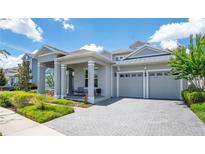 Charming home with a two-car garage, covered porch with ample seating, and paver driveway at 14189 Larkspur Lake Dr, Winter Garden, FL 34787