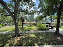 Traditional single-story home with a well-maintained lawn, mature trees, and a large driveway at 1730 Oneco Ave, Winter Park, FL 32789