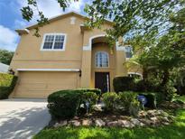 Two-story home with an attached two-car garage, stucco exterior, and landscaped front yard at 2020 Rushden Dr, Ocoee, FL 34761