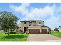 Beautiful two-story home with three-car garage, landscaped yard and brick paver driveway at 2118 Whiting Trl, Orlando, FL 32820