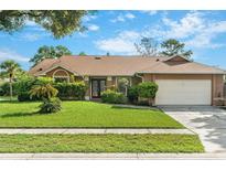 Charming single-story home with well-maintained landscaping, lush lawn and a two car garage at 2809 Gulf Winds Ct, Oviedo, FL 32765