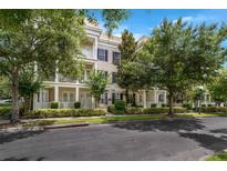 Beautiful townhouse showcasing manicured landscaping and a charming facade with balconies and pillars at 4385 Wardell Pl # 13, Orlando, FL 32814
