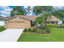 Charming single-story home featuring a two-car garage, well-manicured lawn, and lush landscaping at 4390 Carolwood St, Orlando, FL 32812