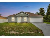 Charming single-story home with a well-maintained lawn and attached two-car garage at 446 Arkansas Ct, Poinciana, FL 34759