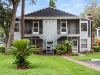 Inviting two-story condo featuring a well-manicured lawn and charming staircases leading to screened balconies at 507 Northlake Dr # 507, Sanford, FL 32773